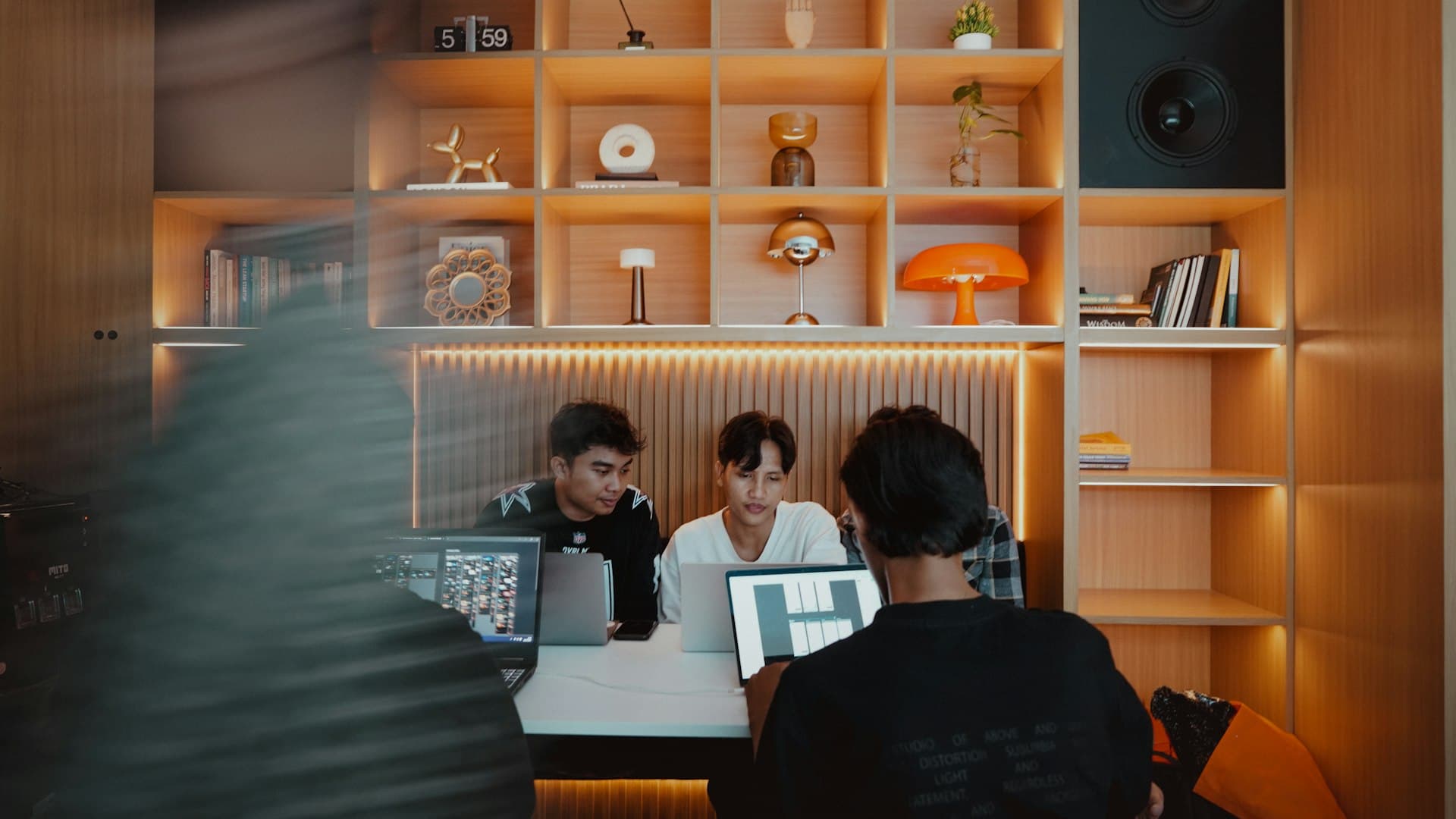 People collaborating around laptops at a shared table